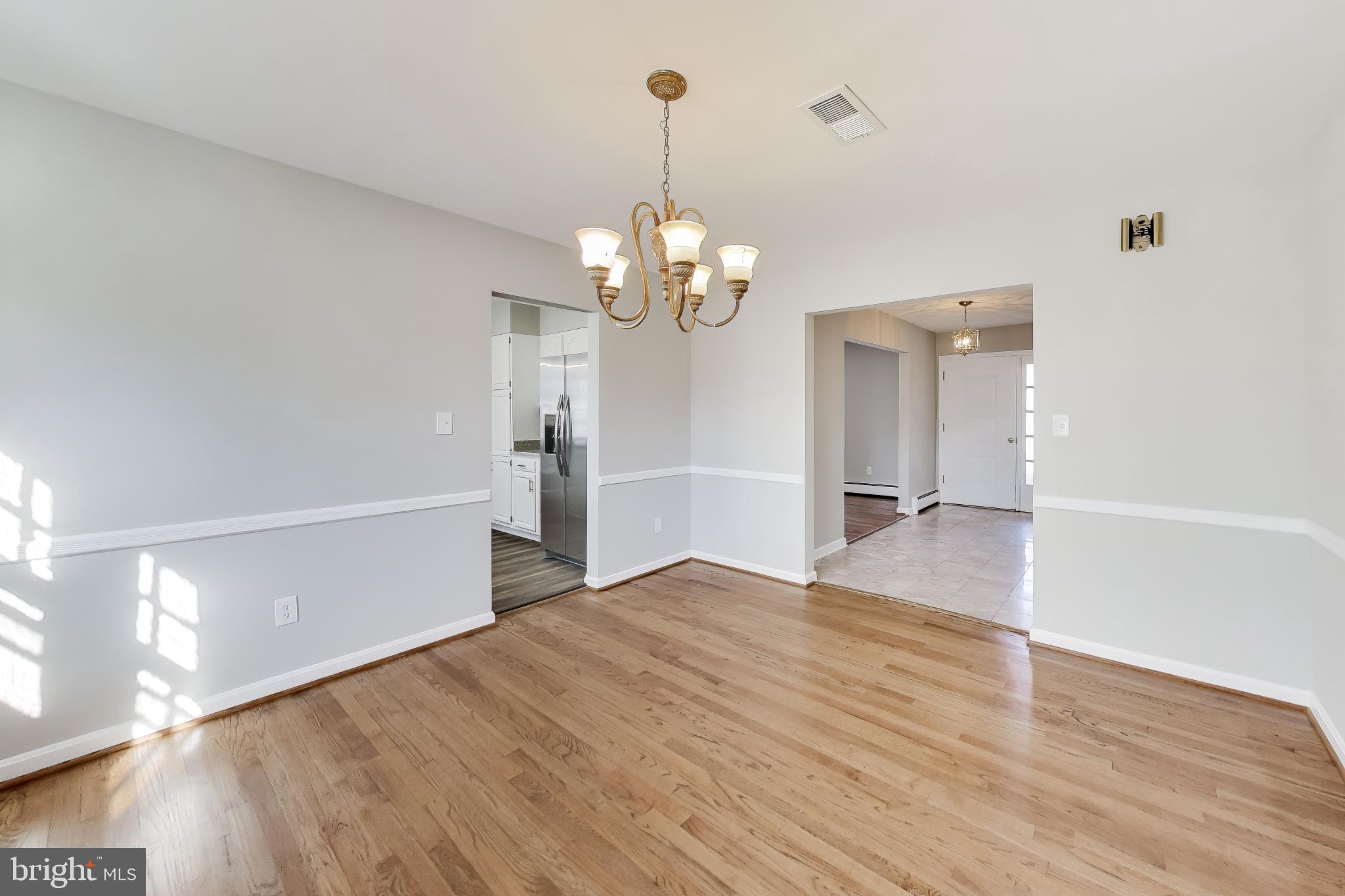 4007 Harrison Road Beltsville, MD 20705 - Photo 10 of 49 a view of a room with wooden floor staircase and a kitchen