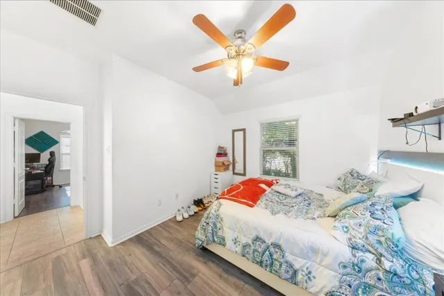 a bedroom with a large bed and a chandelier