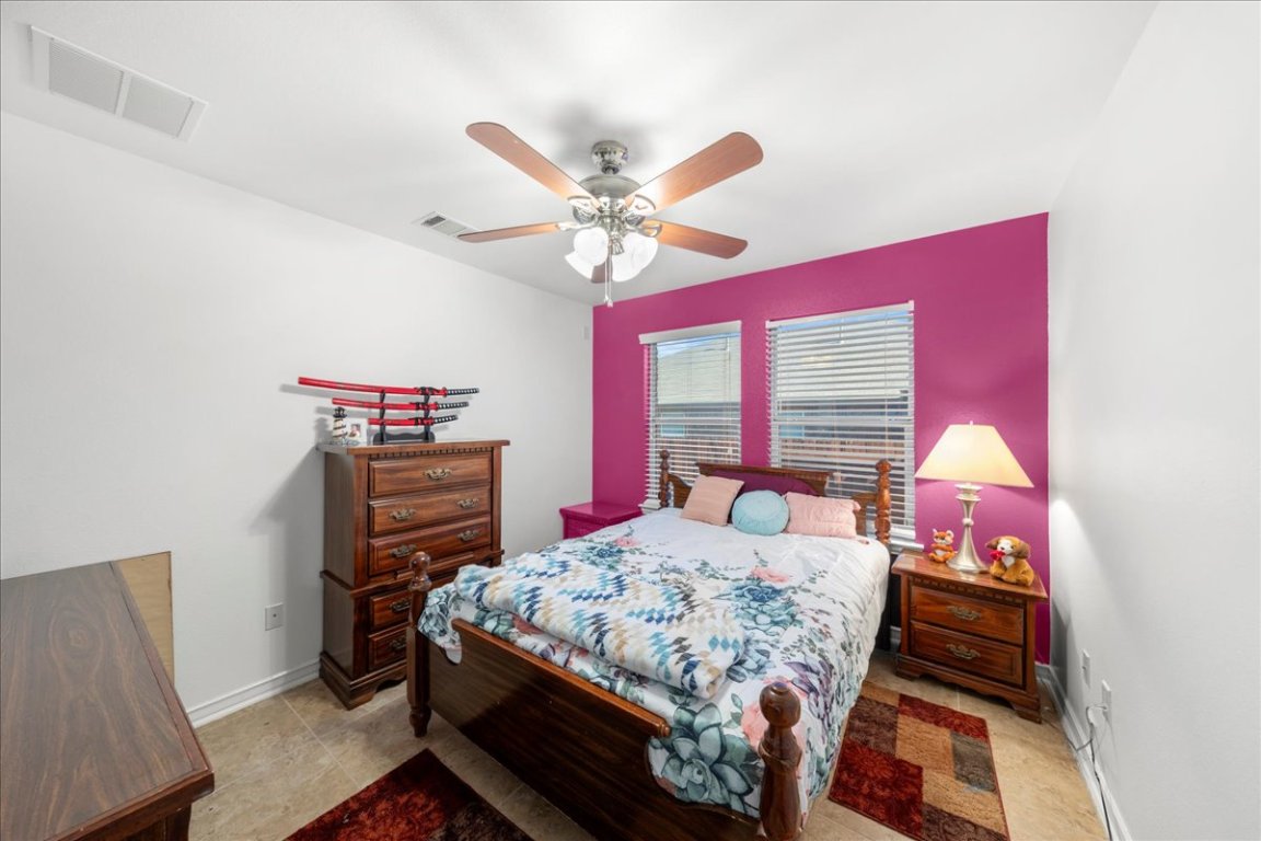 349 Razzmatazz Trail Buda, TX 78610 - Photo 14 of 40 a bedroom with a bed and a chandelier