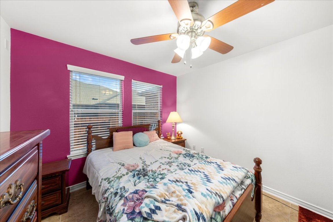 349 Razzmatazz Trail Buda, TX 78610 - Photo 15 of 40 a bedroom with a bed and a chandelier