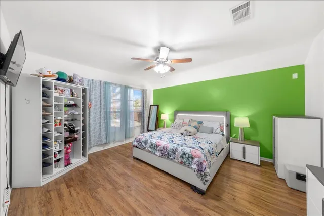 a bedroom with a bed a desk and book shelfs
