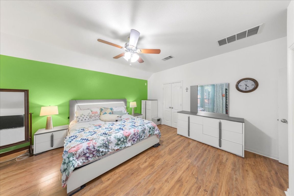 349 Razzmatazz Trail Buda, TX 78610 - Photo 31 of 40 a bedroom with a bed a chandelier and dresser