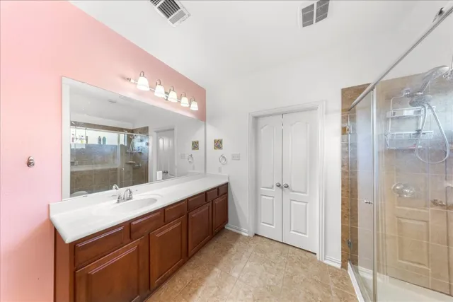 a bathroom with a double vanity sink mirror and shower