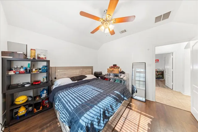 a bedroom with a bed a window and dresser
