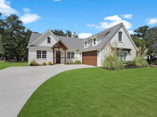 a front view of a house with a yard and trees