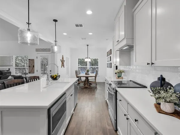 a kitchen with a sink a stove and chairs