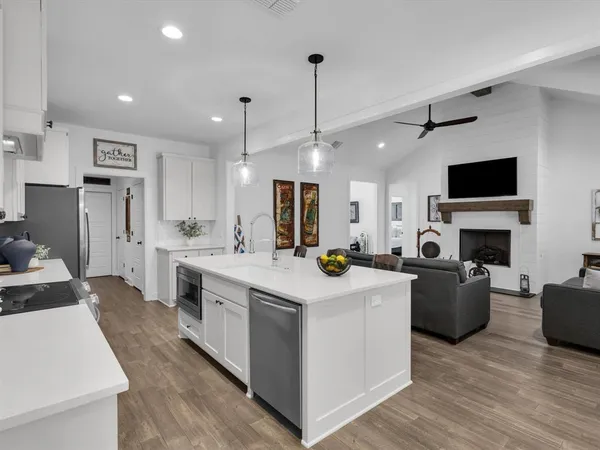 a kitchen that has a lot of cabinets a sink and a stove in it