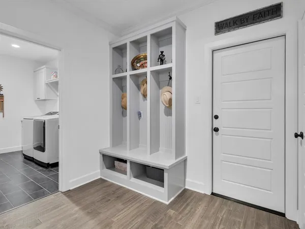 a view of an entryway with wooden floor and cabinet