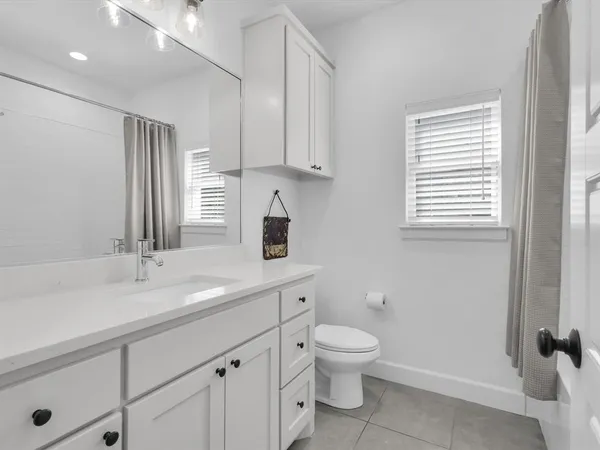 a bathroom with a toilet sink a mirror and vanity
