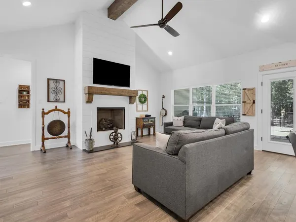 a living room with furniture a flat screen tv and a fireplace