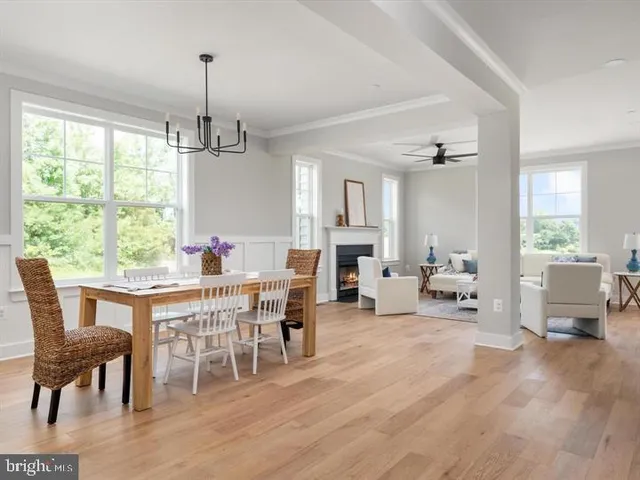 a view of a dining room and livingroom with furniture wooden floor a chandelier