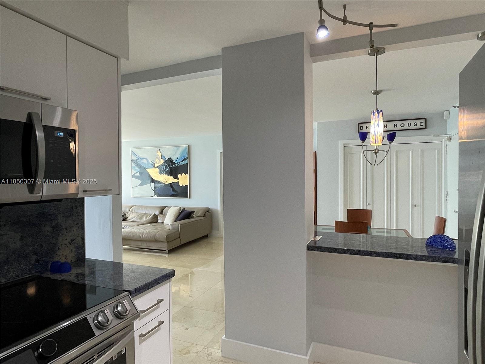 5151 Collins Avenue, Unit 825 Miami Beach, FL 33140 - Photo 13 of 28 a living room with furniture and a flat screen tv