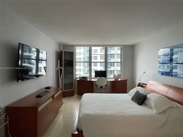 a bedroom with a bed and a flat tv screen