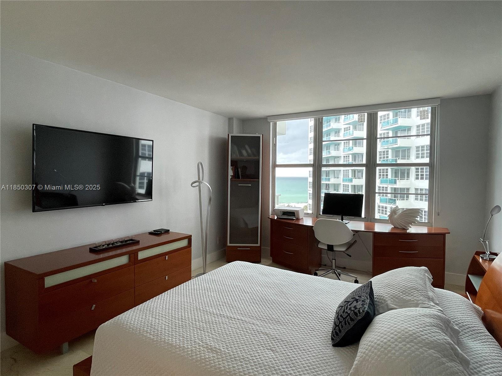 5151 Collins Avenue, Unit 825 Miami Beach, FL 33140 - Photo 19 of 28 a bedroom with a bed and a flat screen tv