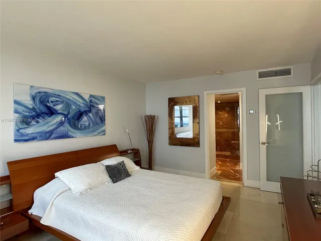 a bedroom with a bed and painting on the wall