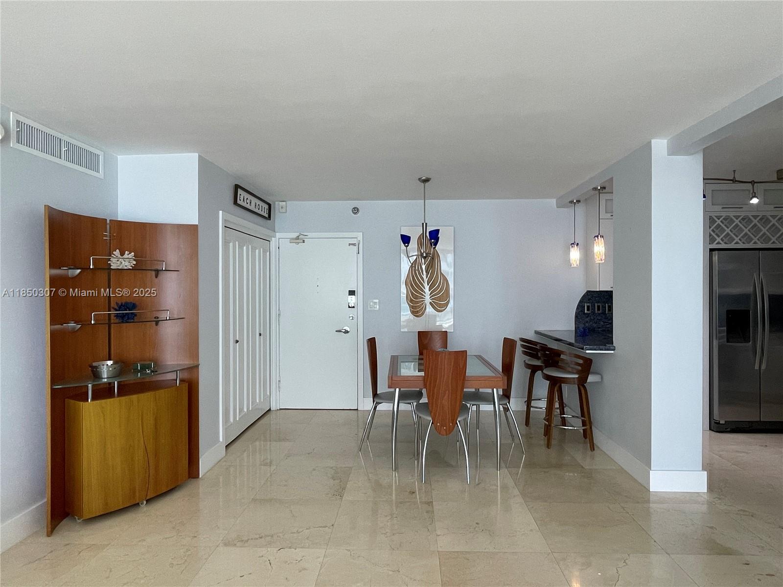 5151 Collins Avenue, Unit 825 Miami Beach, FL 33140 - Photo 5 of 28 a dining room with furniture and kitchen view