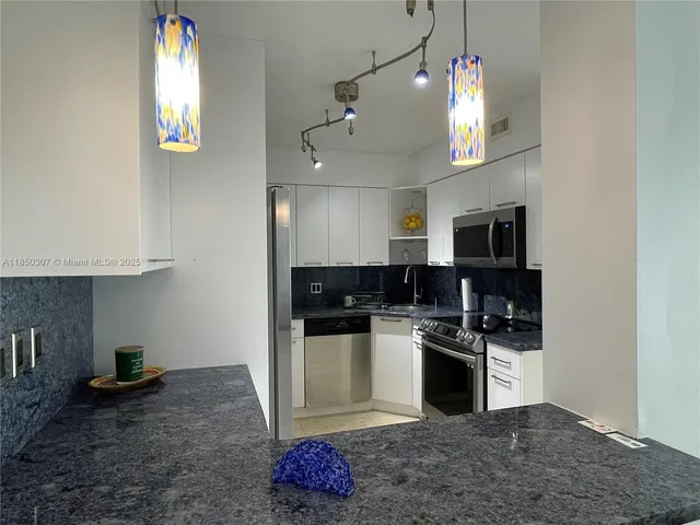 a kitchen with stainless steel appliances granite countertop a sink and a stove