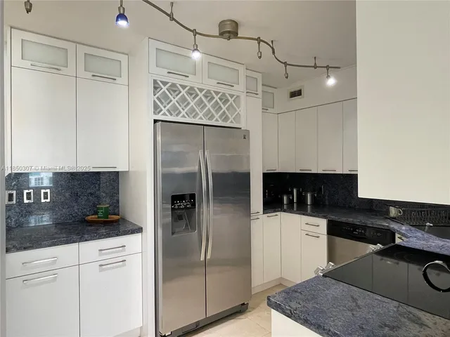 a kitchen with a refrigerator a sink and cabinets