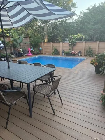 a view of a patio with table and chairs under an umbrella
