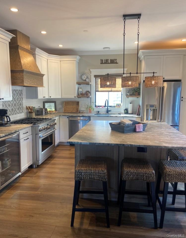 224 Wilmot Road Ocean Beach, NY 11770 - Photo 2 of 17 a kitchen with a table chairs sink and cabinets