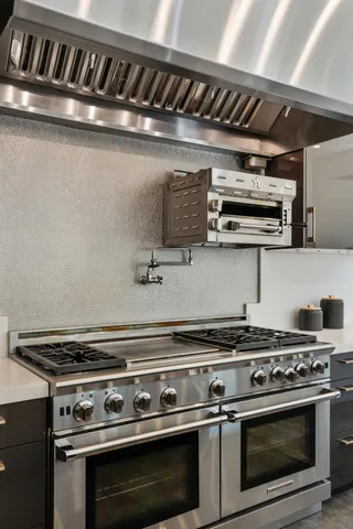 a kitchen with stainless steel appliances kitchen island granite countertop a sink and cabinets