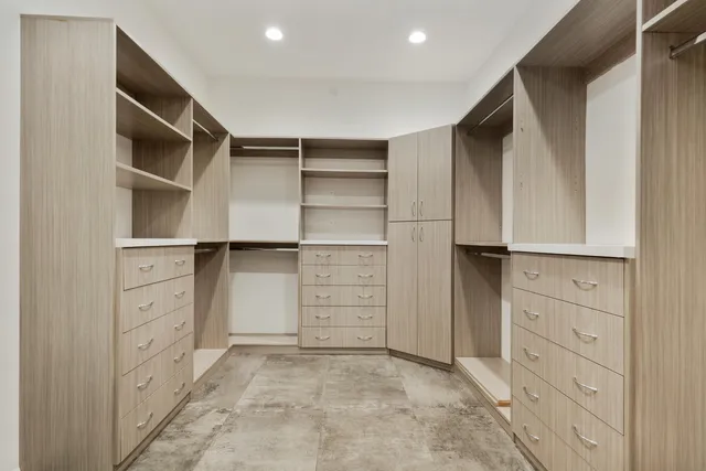 a bedroom with a bed and a lamp on dresser