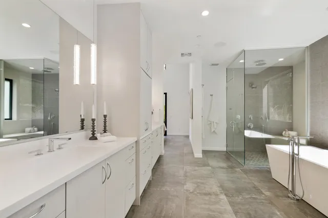 a view of a backyard with couches plants and large trees