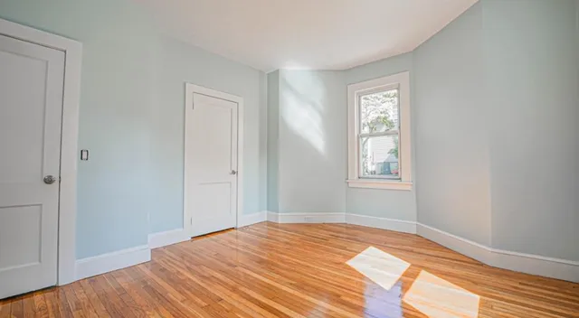 a view of a bedroom with wooden floor and bathroom