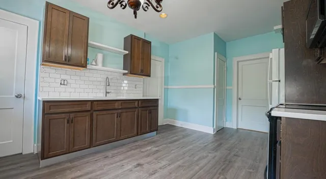 a spacious bathroom with stainless steel appliances granite countertop a sink and wooden cabinets