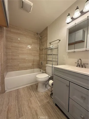 a bathroom with a toilet a sink a mirror and bathtub