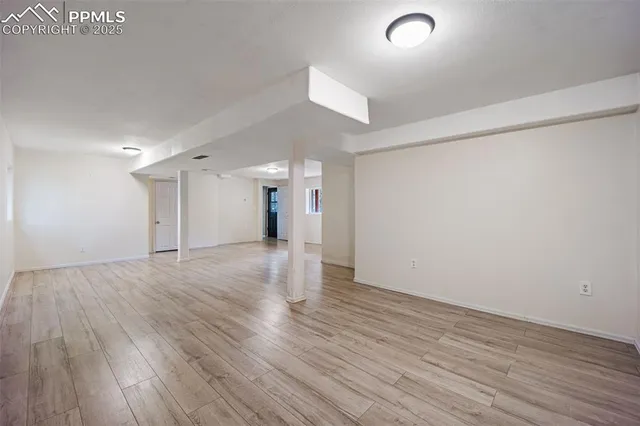 a view of an empty room with wooden floor