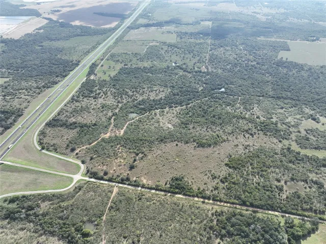 a view of a dry yard with wooden fence