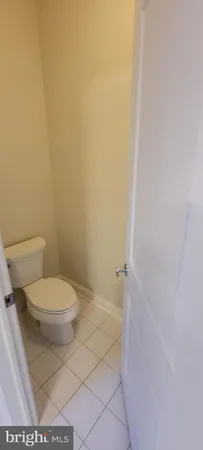 a white toilet sitting next to a white wall