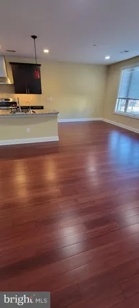 a view of a room with wooden floor and a flat screen tv