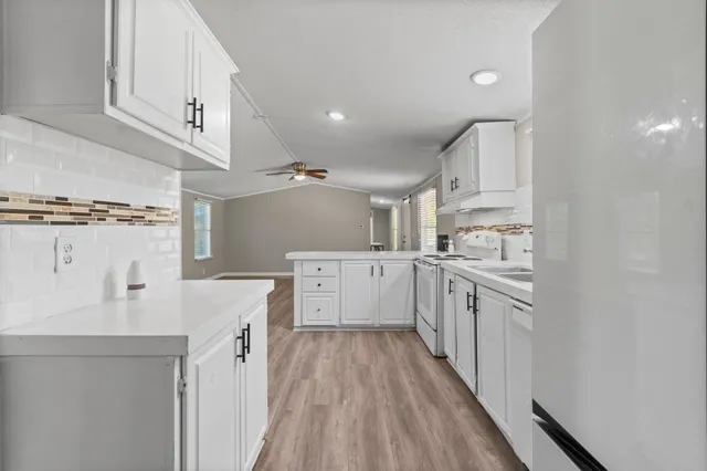 a kitchen with white cabinets appliances and a sink