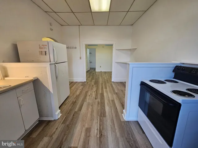a kitchen with wooden floor and a stove top oven