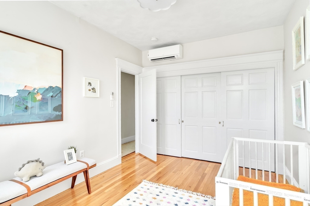 20 John Street, Unit 3 Brookline, MA 02446 - Photo 14 of 23 a bedroom with a bed and wooden floor