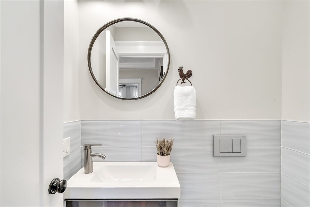20 John Street, Unit 3 Brookline, MA 02446 - Photo 21 of 23 a bathroom with a sink a mirror and a shower