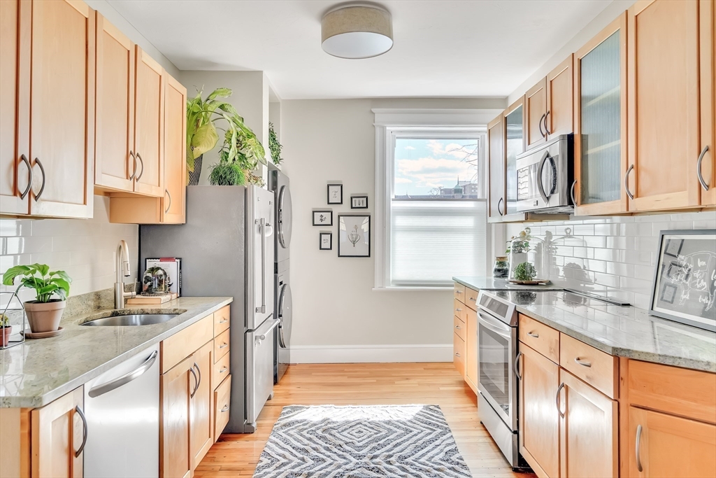 20 John Street, Unit 3 Brookline, MA 02446 - Photo 6 of 23 a kitchen with stainless steel appliances granite countertop a sink stove and cabinets
