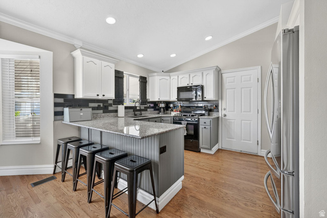 415 East 400 North Santaquin, UT 84655 - Photo 8 of 39 Kitchen featuring wood-finish flooring, white cabinetry, and recessed lighting