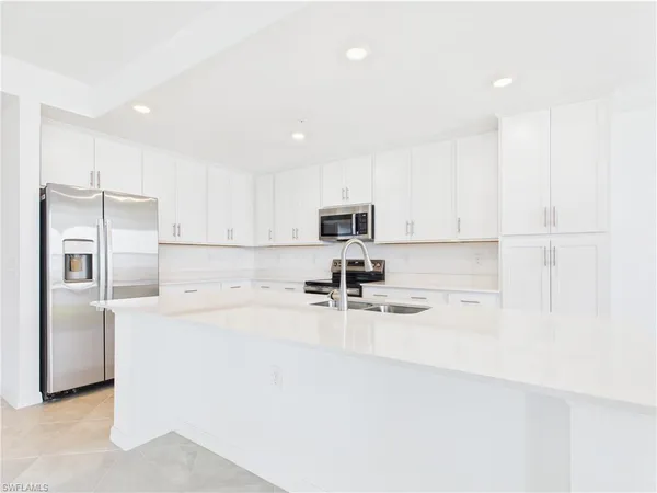 a kitchen with stainless steel appliances a refrigerator sink stove and cabinets
