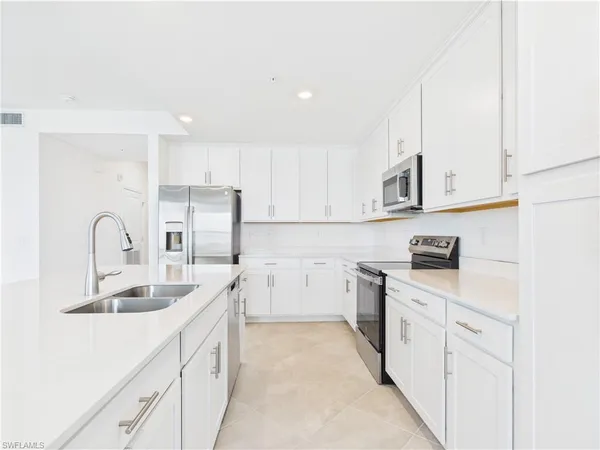 a kitchen with granite countertop white cabinets and white appliances