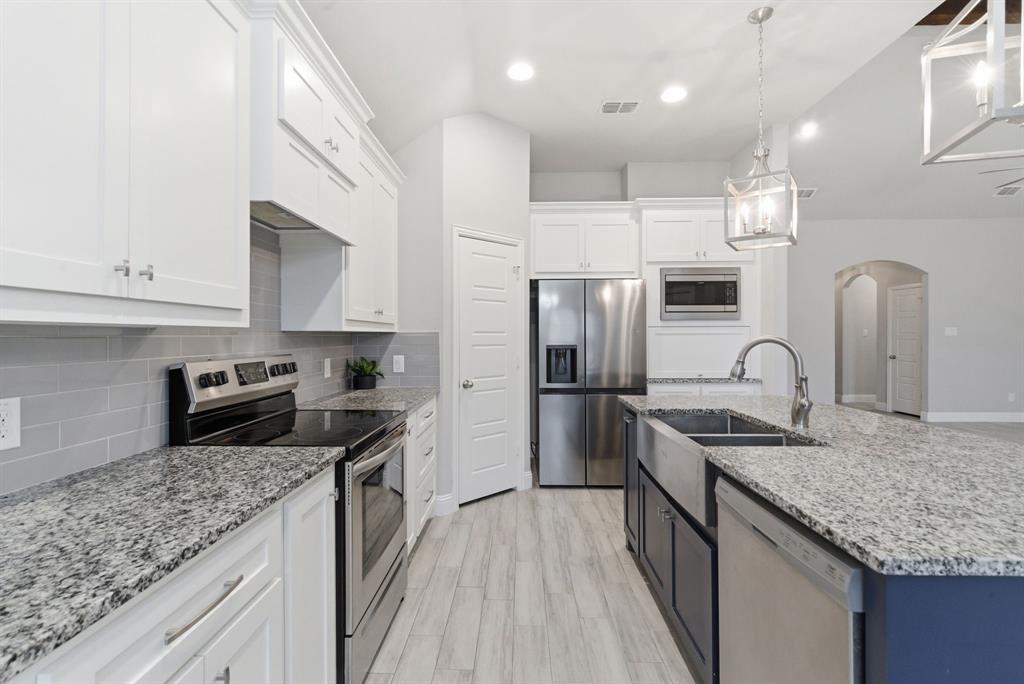972 Sam Street Springtown, TX 76082 - Photo 11 of 34 a kitchen with stainless steel appliances granite countertop a sink dishwasher a refrigerator and a stove with wooden floor
