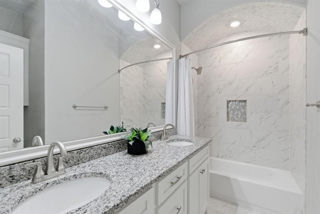 972 Sam Street Springtown, TX 76082 - Photo 24 of 34 a bathroom with a granite countertop sink a mirror a shower and a bathtub
