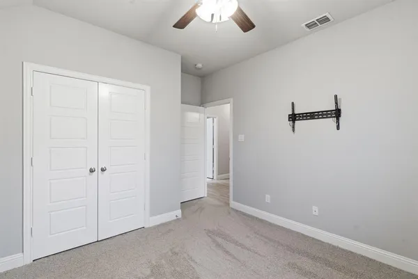 an empty room with a window and ceiling fan