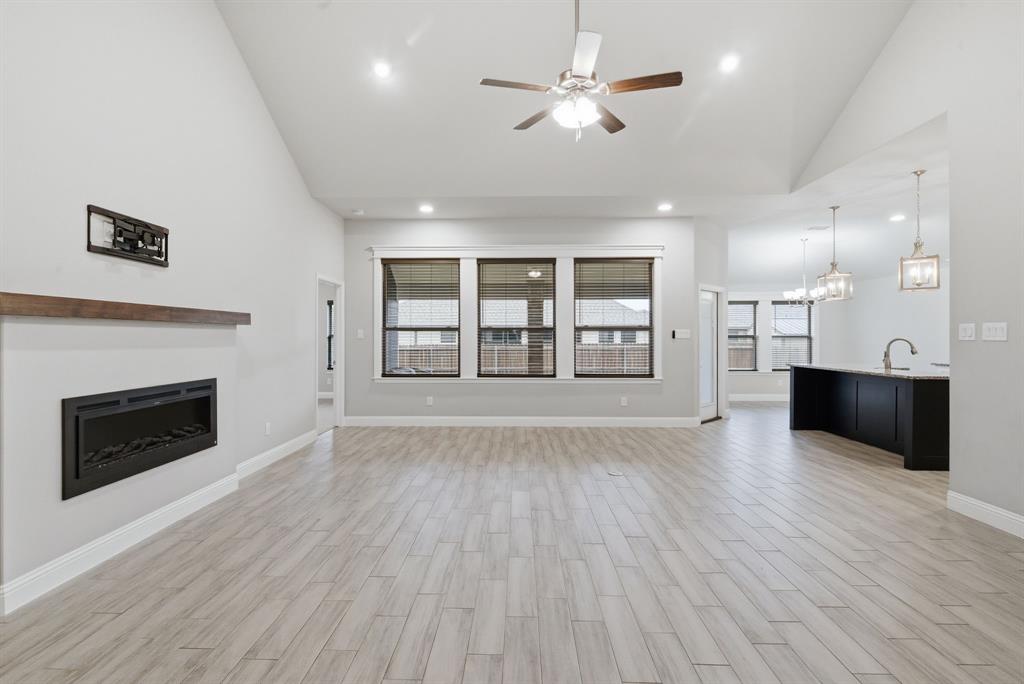 972 Sam Street Springtown, TX 76082 - Photo 5 of 34 a view of an empty room with a fireplace and wooden floor