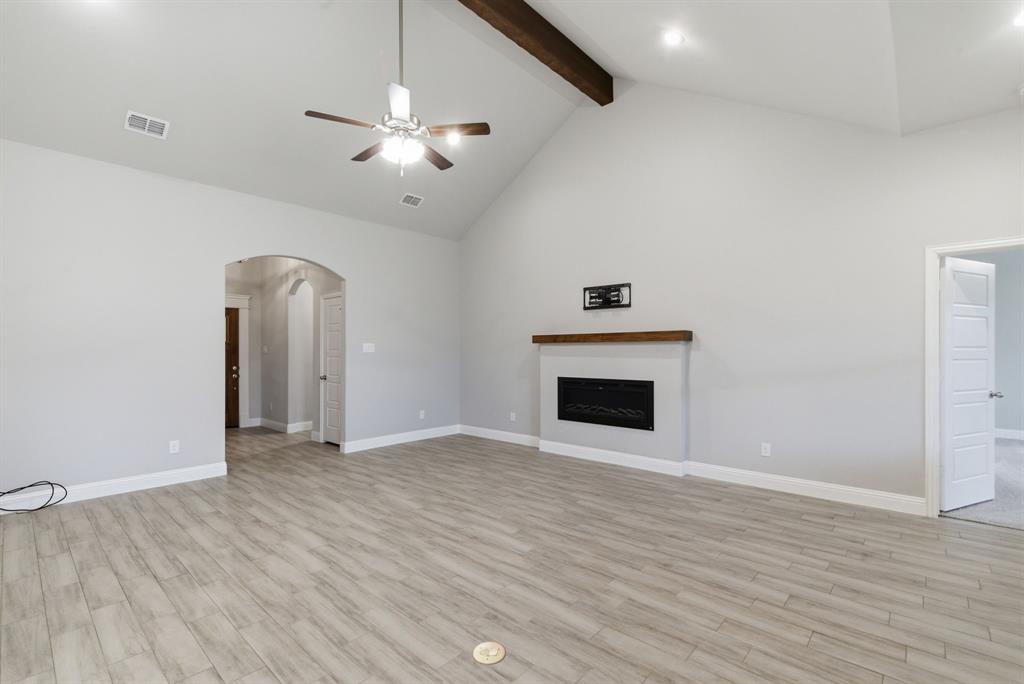 972 Sam Street Springtown, TX 76082 - Photo 7 of 34 a view of an empty room with wooden floor and a fireplace