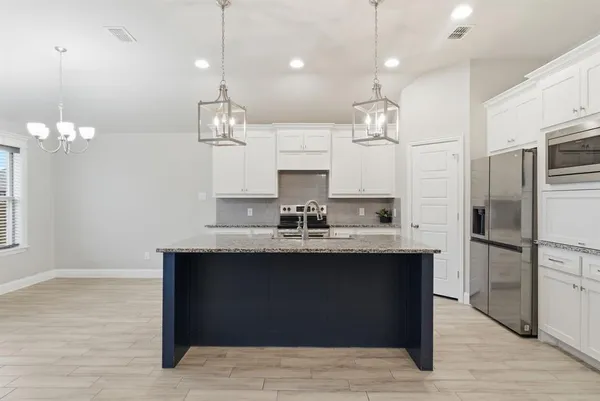 a kitchen with kitchen island a sink stainless steel appliances and cabinets