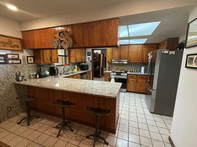 a kitchen with stainless steel appliances granite countertop a sink stove window and cabinets