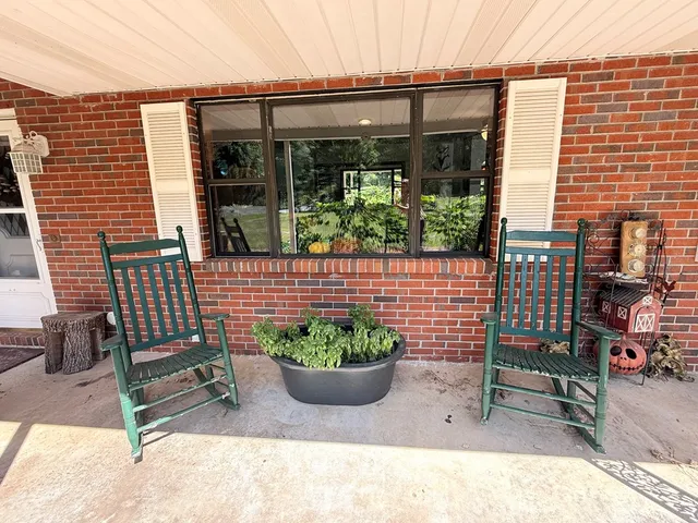 a view of a chair and table in the back yard of the house